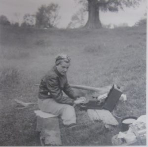 Elsie Jury writing on a typewriter in the field